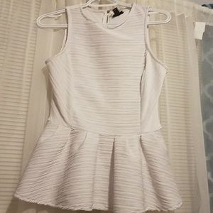 Flared white sleeveless top.